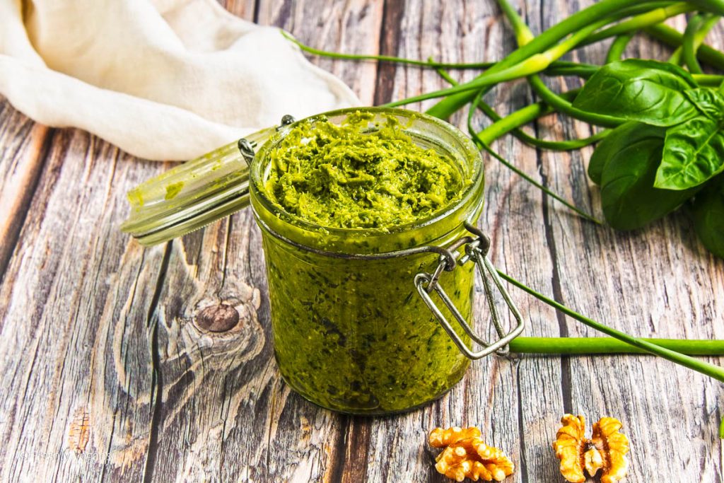 A mixture of garlic scape pesto in a transparent jar.