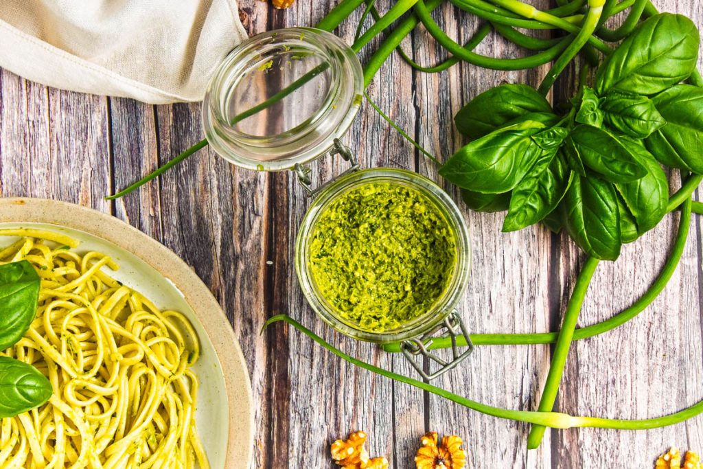 top view of garlic scape pesto sauce in a transparent jar.